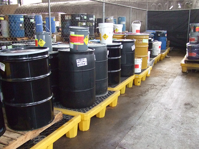 Labeled hazardous material drums staged for compliance handling